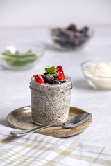 angled shot of chia pudding in glass jar, with key ingredients