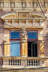 Fototapeta na wymiar Window of a beautiful old building at Piata Cuza Voda or Cuza Voda Square in Aiud, Alba County, Transylvania, Romania behind electrical cables