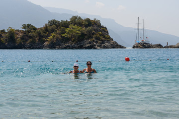 Women are posing in shallow water of Oludeniz beach, Turkey.