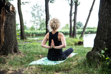 Kobieta ćwicząca jogę nad jeziorem - obrazy, fototapety, plakaty