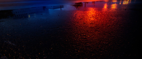 Background of wet asphalt with neon light. Blurred background, night lights, reflection. Night city, dark street.