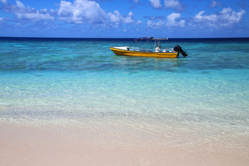 Tourist boat anchored at Gee island in Ouvea lagoon, Loyalty Islands, New Caledonia