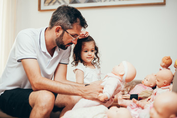 Father and daughter playing doll in living room