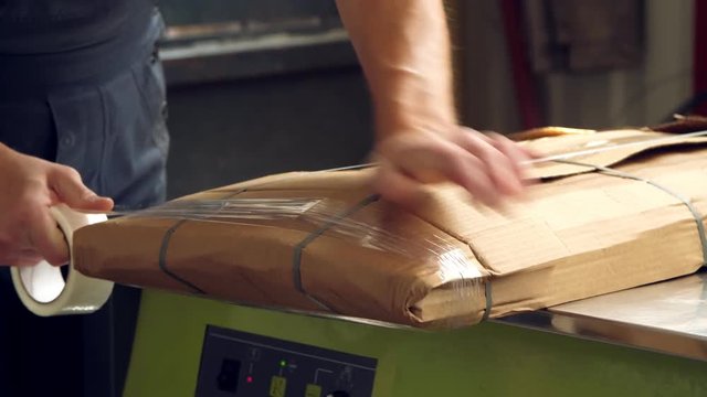 packaging furniture products. close-up. The worker carefully wraps the furniture items in cardboard packaging, prepares them for transportation.