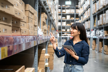 Young asian woman auditor or trainee staff work looking up and checks the number of items store by...