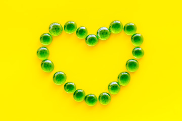 Shiny glass stones for decoration, creativity and craft on yellow background top view copyspace