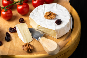 cheese board - camembert cheese with nuts, cranberries and cherry tomatoes