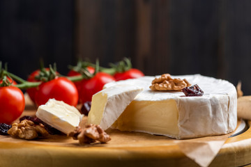 cheese board - camembert cheese with nuts, cranberries and cherry tomatoes