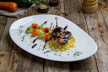 Duck leg confit on wooden background