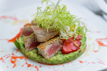 Tuna tar tar with mashed avocado on white plate