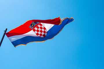 Croatia flag flapping in the wind with blue sky background