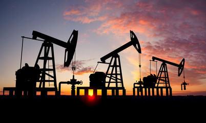 Fototapeta na wymiar Three oil pumps at sunset