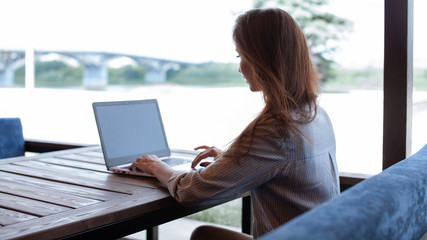 Young sensitive woman using laptop computer in the street cafe outdoor. Freelance work concept. Summer restaurant outdoor. Learning foreign languages online. Lesson with tutor. Typing on a keyboard.