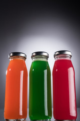 low angle view of glass bottles with multicolored liquid on dark background with back light