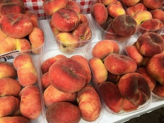 Boxes of saturn peaches sold at a market in Croatia.  The flat peach (Prunus persica var. platycarpa), also known as the doughnut peach or Saturn peach, is a variety of peach with pale yellow fruit.