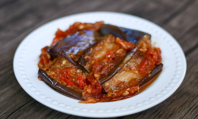 Terong balado (eggplants with chili sauce) on wood background. Indonesian cuisine from Padang, West Sumatra.