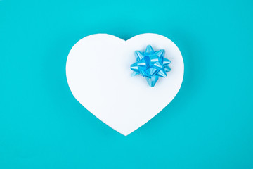 White heart shaped gift box with blue bow for holiday, christmas, thanks giving day, birthday top...