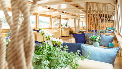 The interior of the urban river ship, with a panoramic view of the urban landscape. The concept of tourism, recreation, walking around the city, rest in the city. River transport.