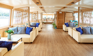 The interior of the urban river ship, with a panoramic view of the urban landscape. The concept of tourism, recreation, walking around the city, rest in the city. River transport.