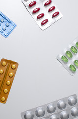 packings of pills and capsules of medicines in different position on white background
