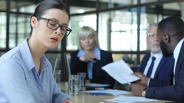 Woman employee shocked with quarreling business people at meeting, office mess