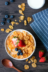 Breakfast cereal bowl with healthy blueberries and strawberries goes well with milk. Blue white stripes napkin