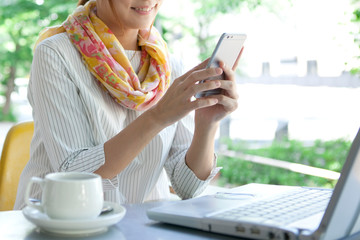 カフェでスマートフォンを操作する女性