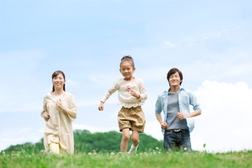 野原を走る家族3人