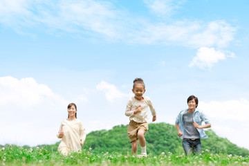 野原を走る家族3人