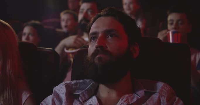 Young man watching movie in cinema