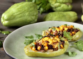 chayote stuffed baked stuffed with minced meat, corn and pieces of the chayot with cheese sauce
