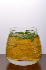 Refreshing drink with gas bubbles. Nalit in a transparent glass. It laid crushed ice. Decorated with mint leaves.