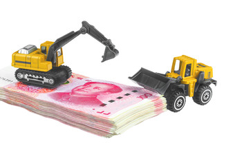 Wheel loaders and backhoe heavy duty vehicle model construct on the pile of chinese banknote (Yuan), business and money construction or investment concept..