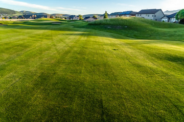 Fairway and bunkers of a golf course with homes and mountain in the distance