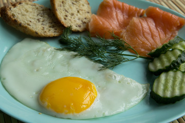 Fried eggs,fish salmon, cucumbers, whole grain bread