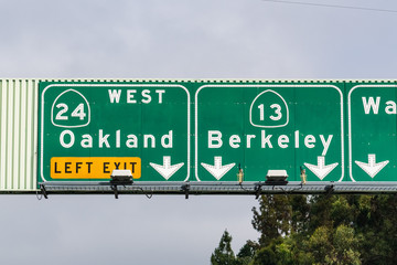 Freeway signage providing information about the lanes going to Oakland and Berkeley; San Francisco bay area, California