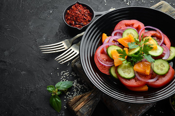 Vegetable salad. Tomatoes, cucumber, onions, parsley. Top view. Free space for your text.