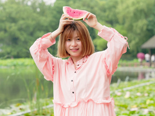 Summer woman having fun with watermelon slice. Smiling Chinese girl eating watermelon in park. Holiday lifestyle. Brunette woman eat fresh watermelon. Happiness, joy, holiday, summer concept.