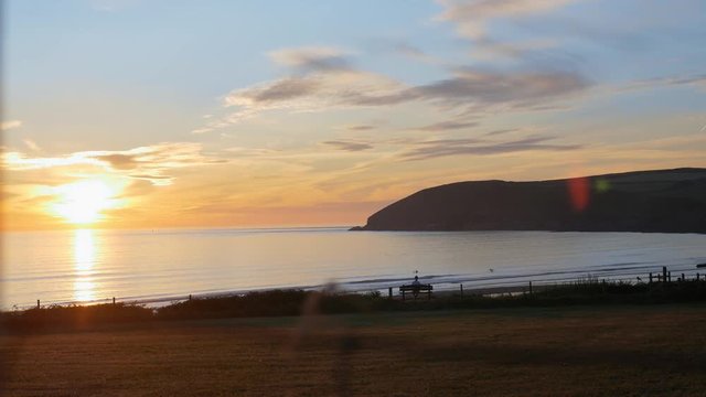 A sunset over Croyde Bay, Baggy Point can be seen on the right.