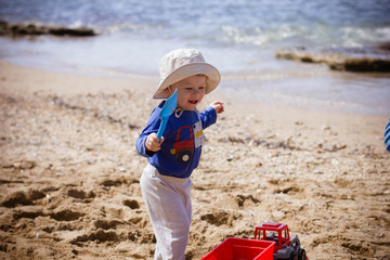 little boy playing with toys on the beach