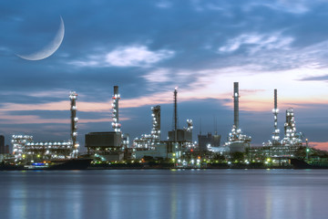Naklejka premium Double Exposure, C-shaped section or Crescent of the moon surface with Oil refinery industry plant near the river before sunrise.