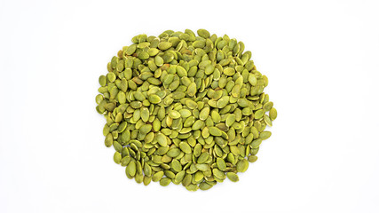 Green pumpkin seeds on a white background.