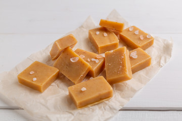 Fresh caramel fudge candies on white rustic background