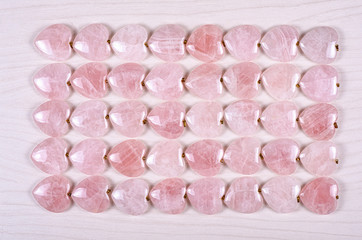Forty rose quartz hearts are stowed five rows. Eight pieces in each one. Top view.