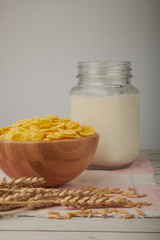 Bowl with Cornflakes and Milk on an wooden table