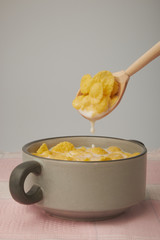 Bowl with Cornflakes and Milk on an wooden table