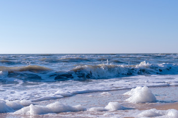 Image of sea foam on a sandy beach.