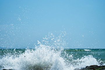 Image of the sea shore. The wave breaks on the stones.
