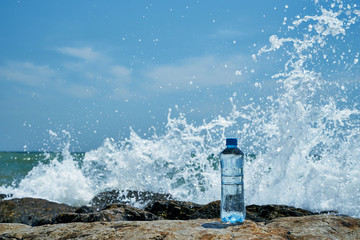 Plastic bottle. Coast of the sea. Waves hit the stones.