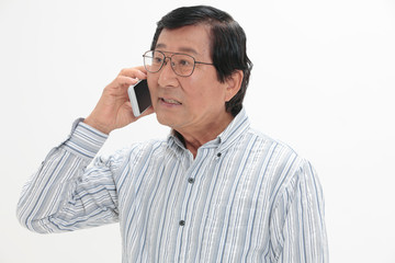 スマートフォンで通話するシニア男性